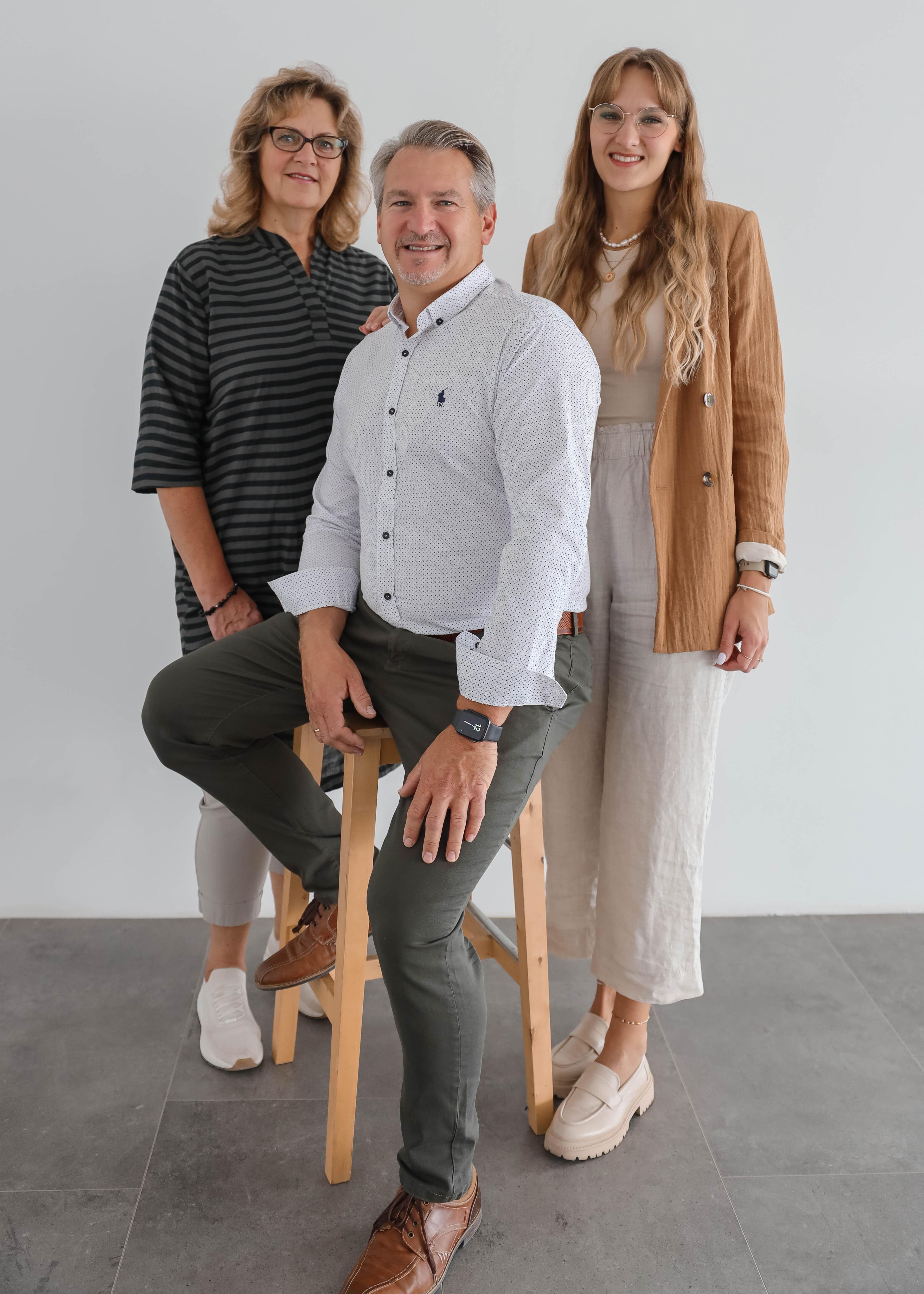 Über Uns — Familien-Porträt drei Personen Inhaberteam menVess in heller Studio-Atmosphäre