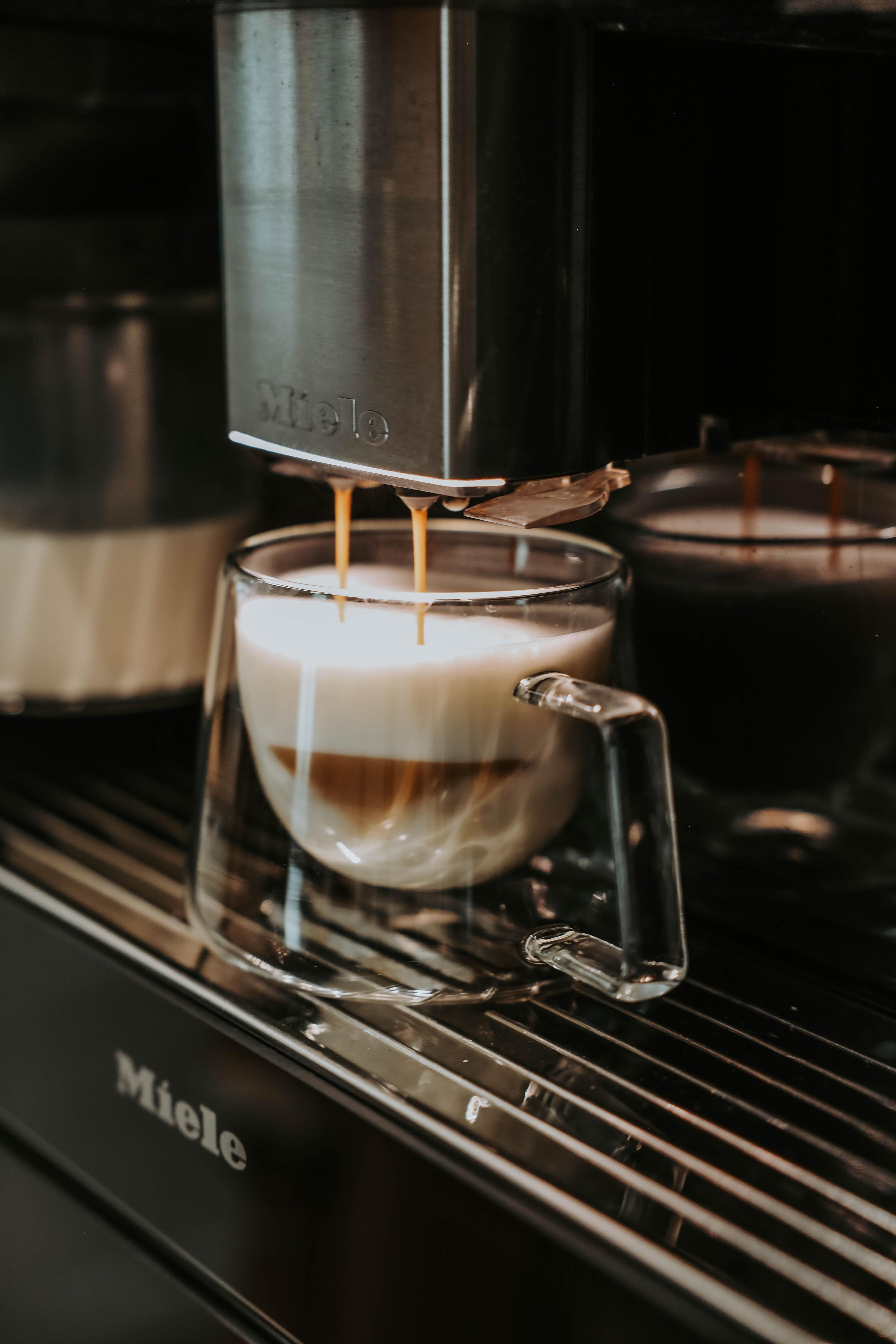 Detailansicht eines Miele Kaffeevollautomaten mit gefüllter Latte-Macchiato-Tasse